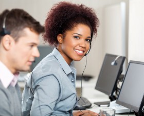 Portrait of confident female employee with male colleague working in call center